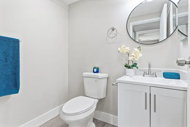 a bathroom with a sink vanity mirror and toilet