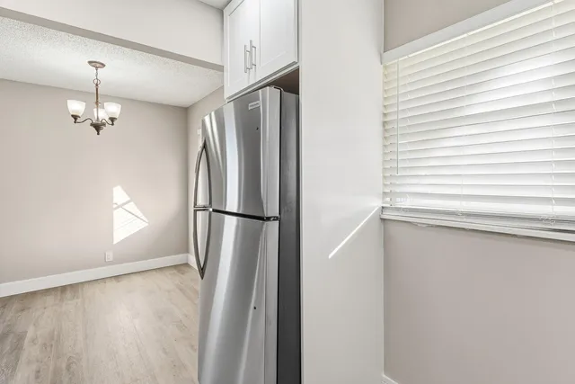 a view of a refrigerator in kitchen and wooden floor