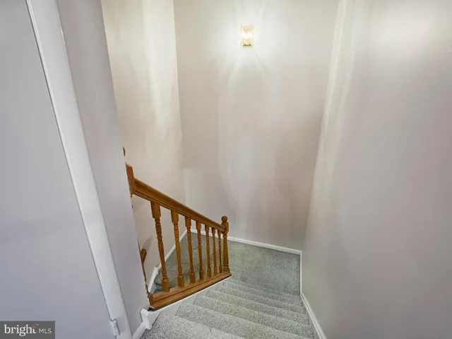 a view of a hallway with wooden floor and stairs