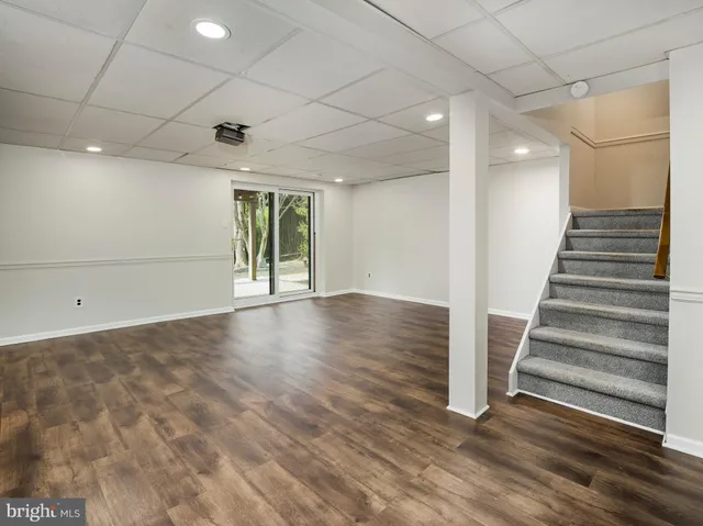 a view of an empty room with wooden floor and entryway