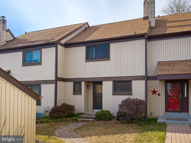 a view of a house with backyard and trees