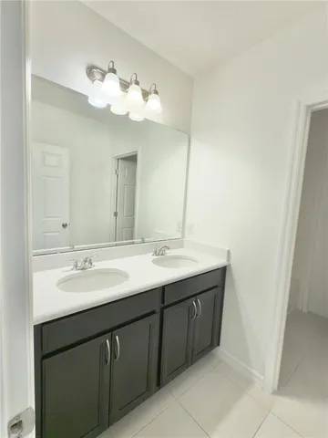 a bathroom with a double vanity sink and a mirror