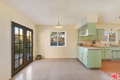 an empty room with windows fireplace and wooden floor