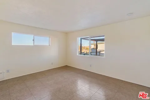 a view of an empty room with cabinet and door