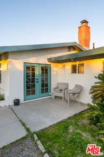 a front view of a house with a tree