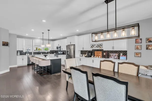 a kitchen with a table chairs refrigerator and microwave