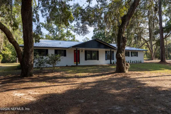 a view of a house with a tree in front of it