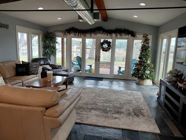 a living room with furniture windows and potted plants