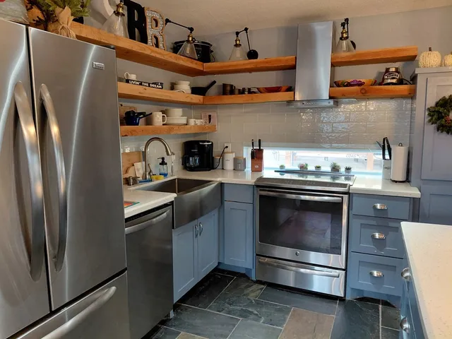 a kitchen with stainless steel appliances granite countertop a stove and a refrigerator