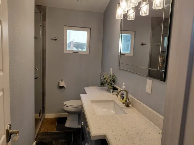 a bathroom with a sink toilet and a mirror