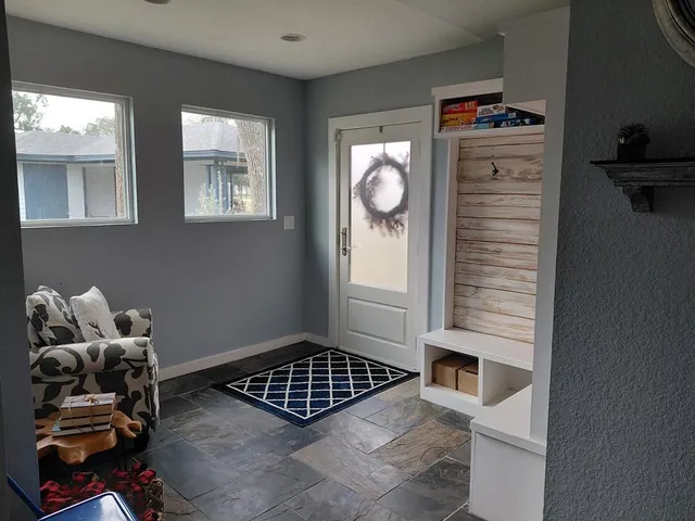 a large bed sitting in a bedroom next to a window with a chandelier