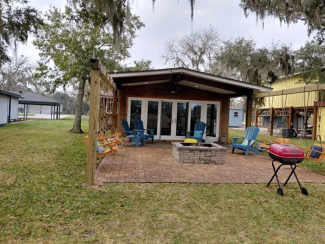 a view of a house with backyard and sitting area