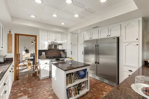 a living room with furniture a flat screen tv and kitchen view
