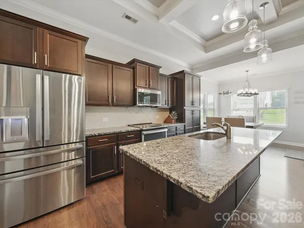 a kitchen with stainless steel appliances granite countertop a sink refrigerator and microwave