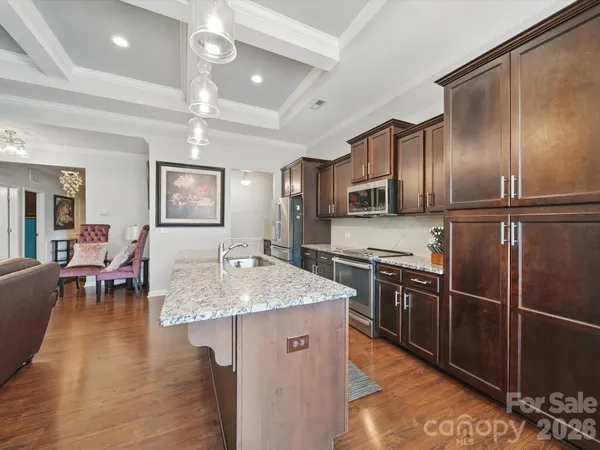 a kitchen with stainless steel appliances granite countertop a sink refrigerator and cabinets