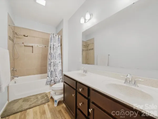 a bathroom with a granite countertop sink a toilet and shower