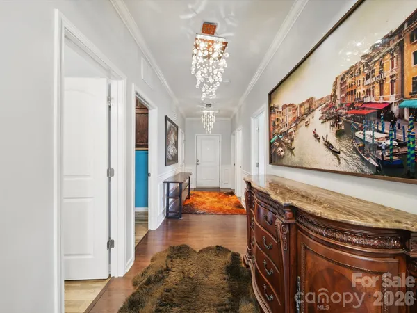 a hallway with painting on the wall and a large mirror