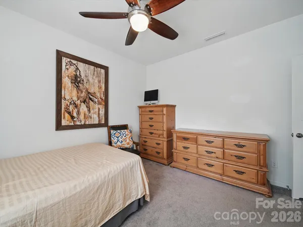 a bedroom with a bed dresser and a baby crib