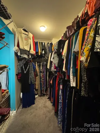 a view of walk in closet with clothes and shoes