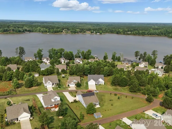 an aerial view of a house with outdoor space and lake view