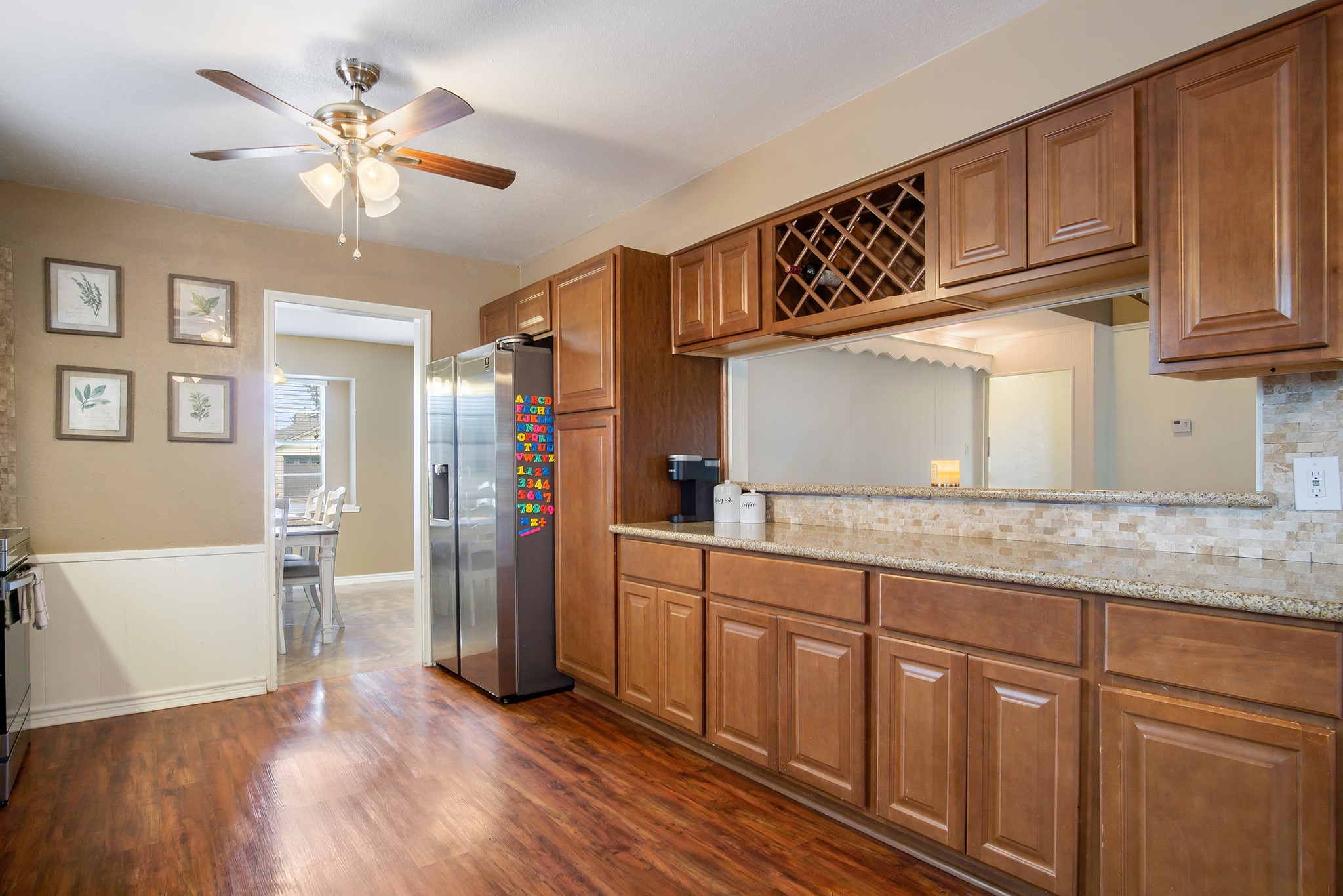 706 Yale Lane Deer Park, TX 77536 - Photo 13 of 43 a kitchen with stainless steel appliances granite countertop a refrigerator a sink dishwasher a dining table and chairs with wooden floor