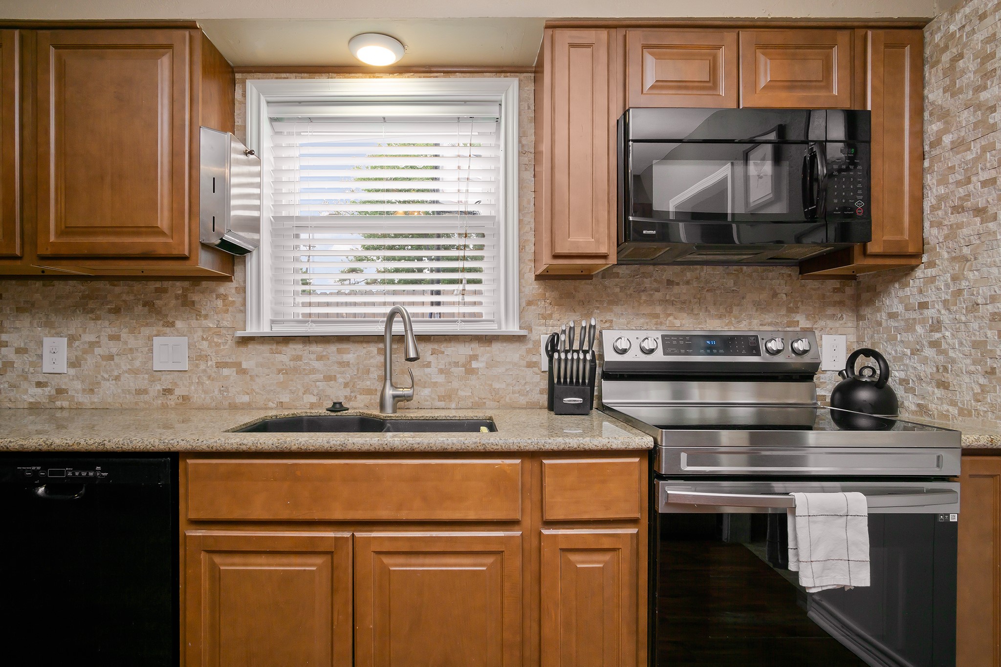 706 Yale Lane Deer Park, TX 77536 - Photo 15 of 43 a kitchen with stainless steel appliances granite countertop a sink stove and microwave