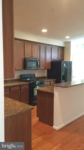 a kitchen with stainless steel appliances wooden cabinets a stove top oven a sink and dishwasher