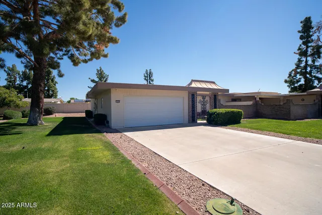 a front view of a house with a yard and a garage