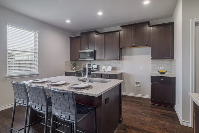 a kitchen with sink and view of living room