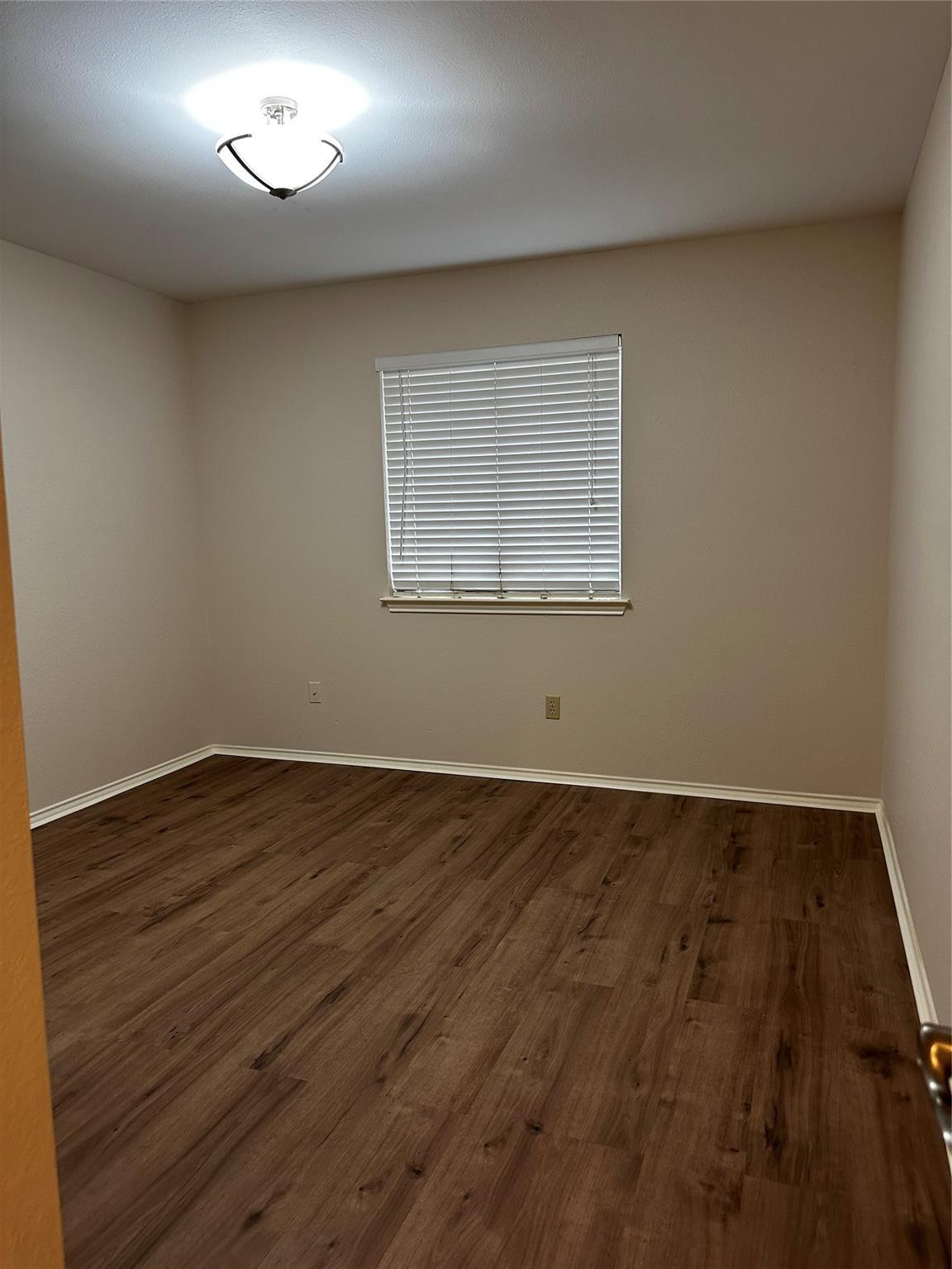 8007 Bounty Trail Austin, TX 78749 - Photo 25 of 32 Rich hardwood-style flooring and a bright ceiling light define this versatile space.