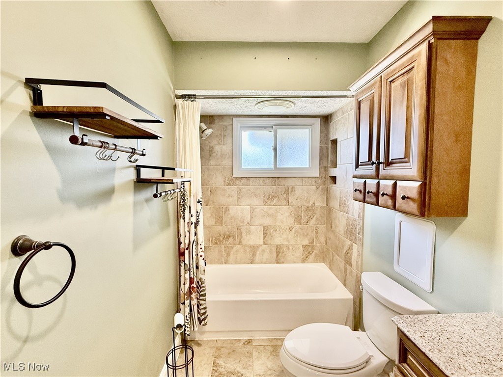 2900 Shellhart Road Barberton, OH 44203 - Photo 13 of 44 Bathroom featuring shower / bath combo with shower curtain and vanity