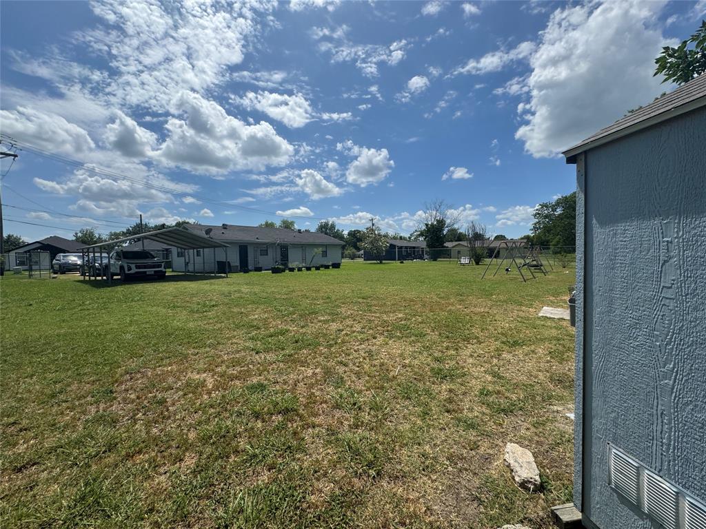 207 College Mound Road Terrell, TX 75160 - Photo 13 of 14 Expansive grassy area featuring a detached storage shed with vinyl siding, a metal carport, and a swing set