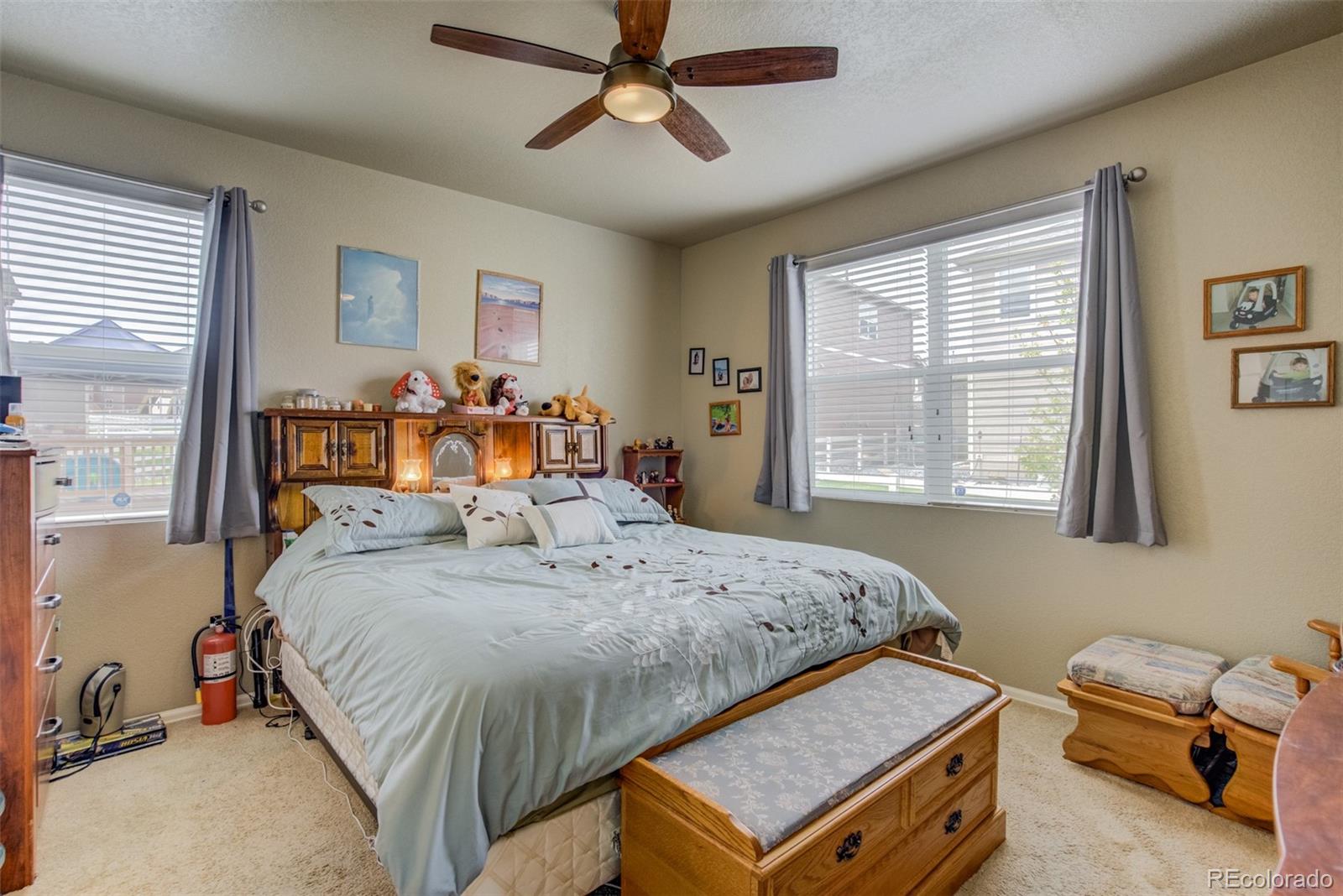 5907 Point Rider Circle Castle Rock, CO 80104 - Photo 13 of 29 a bedroom with a bed and a chandelier