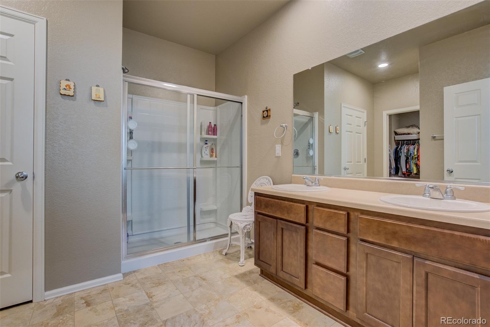 5907 Point Rider Circle Castle Rock, CO 80104 - Photo 16 of 29 a spacious bathroom with a shower sink and mirror
