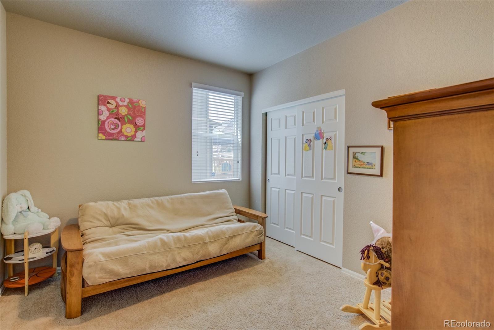 5907 Point Rider Circle Castle Rock, CO 80104 - Photo 19 of 29 a bedroom with a bed and cabinets