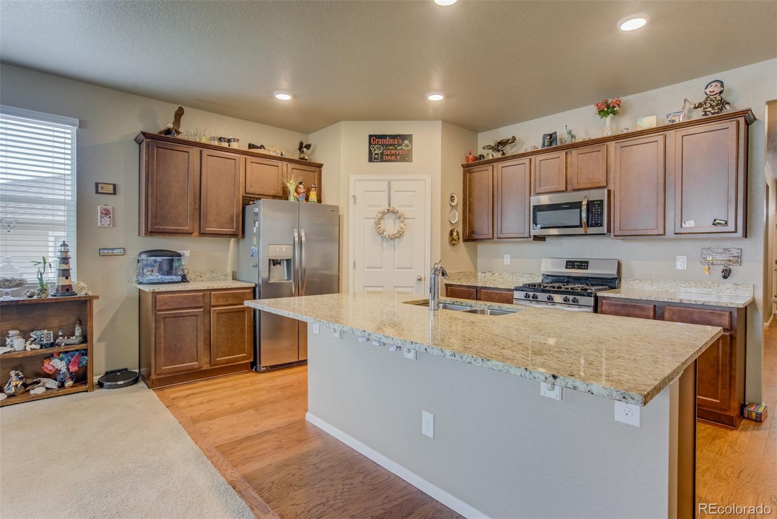 5907 Point Rider Circle Castle Rock, CO 80104 - Photo 3 of 29 a kitchen with kitchen island a counter top space a sink stainless steel appliances and cabinets