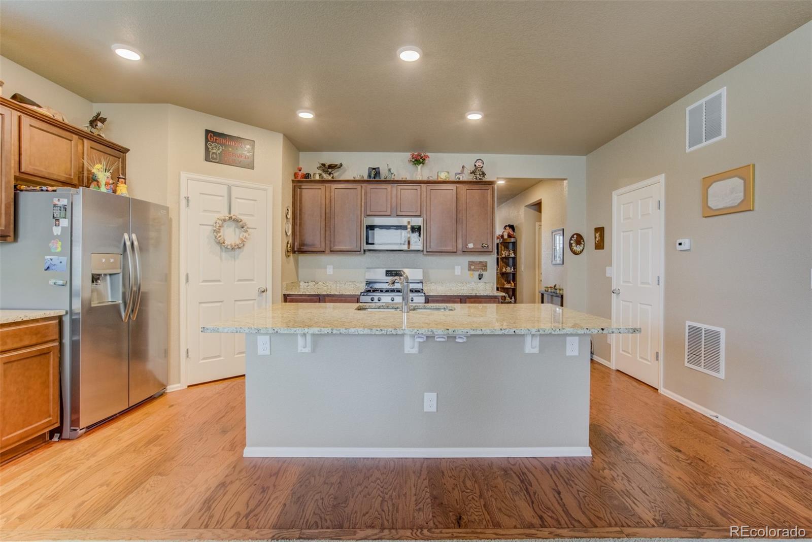 5907 Point Rider Circle Castle Rock, CO 80104 - Photo 4 of 29 a large kitchen with stainless steel appliances a large counter top and a refrigerator