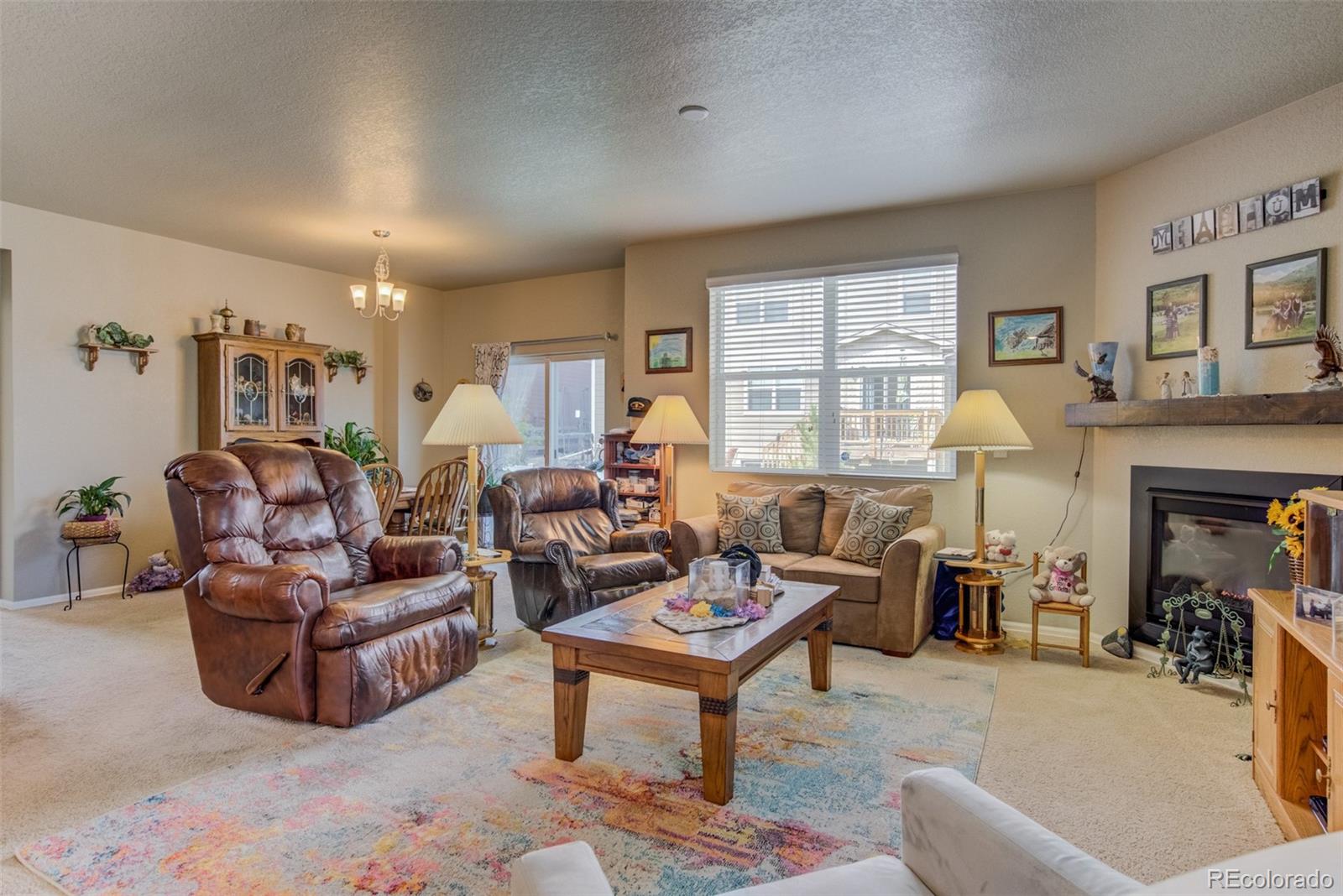 5907 Point Rider Circle Castle Rock, CO 80104 - Photo 6 of 29 a living room with furniture a fireplace and a large window
