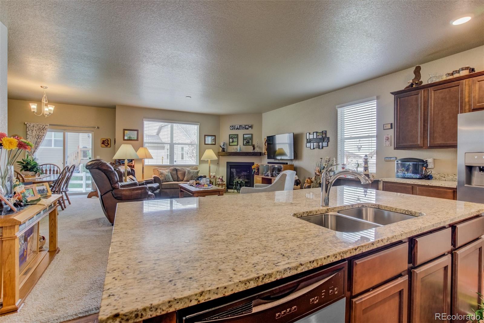 5907 Point Rider Circle Castle Rock, CO 80104 - Photo 9 of 29 a kitchen with sink cabinets and living room