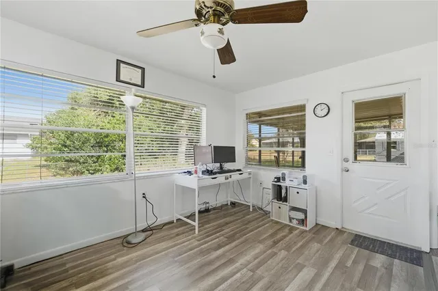a view of a workspace with furniture and a window