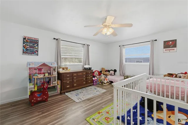 a bedroom with furniture a baby crib and a window