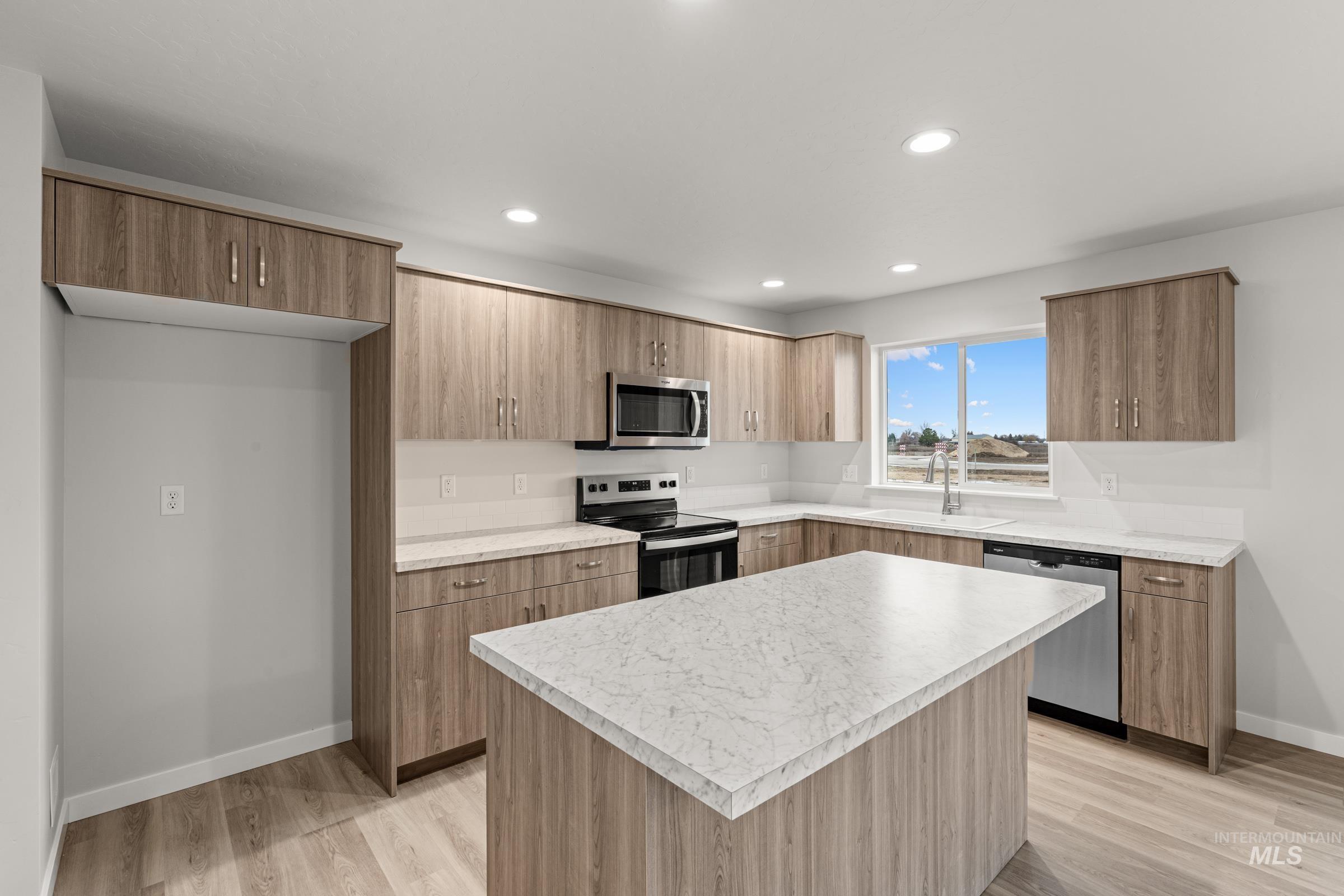 13693 Redway Court Caldwell, ID 83607 - Photo 5 of 25 Kitchen featuring stainless steel appliances, light countertops, a center island, light wood-style flooring, and modern cabinets