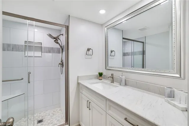 a bathroom with a granite countertop sink a mirror and shower