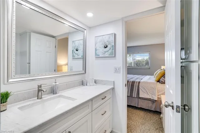 a en suite bathroom with a granite countertop sink and a mirror