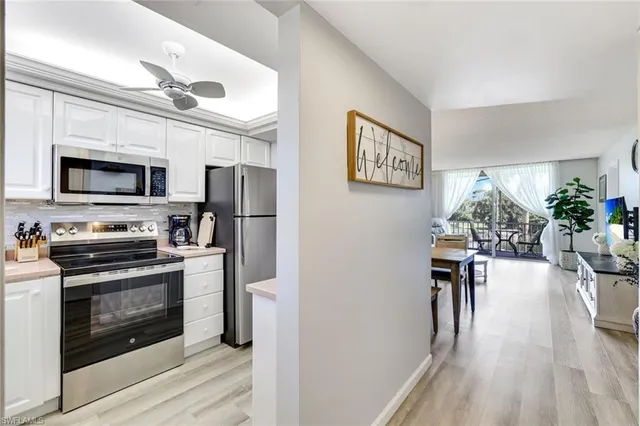 a view of a kitchen with furniture wooden floor and stainless steel appliances