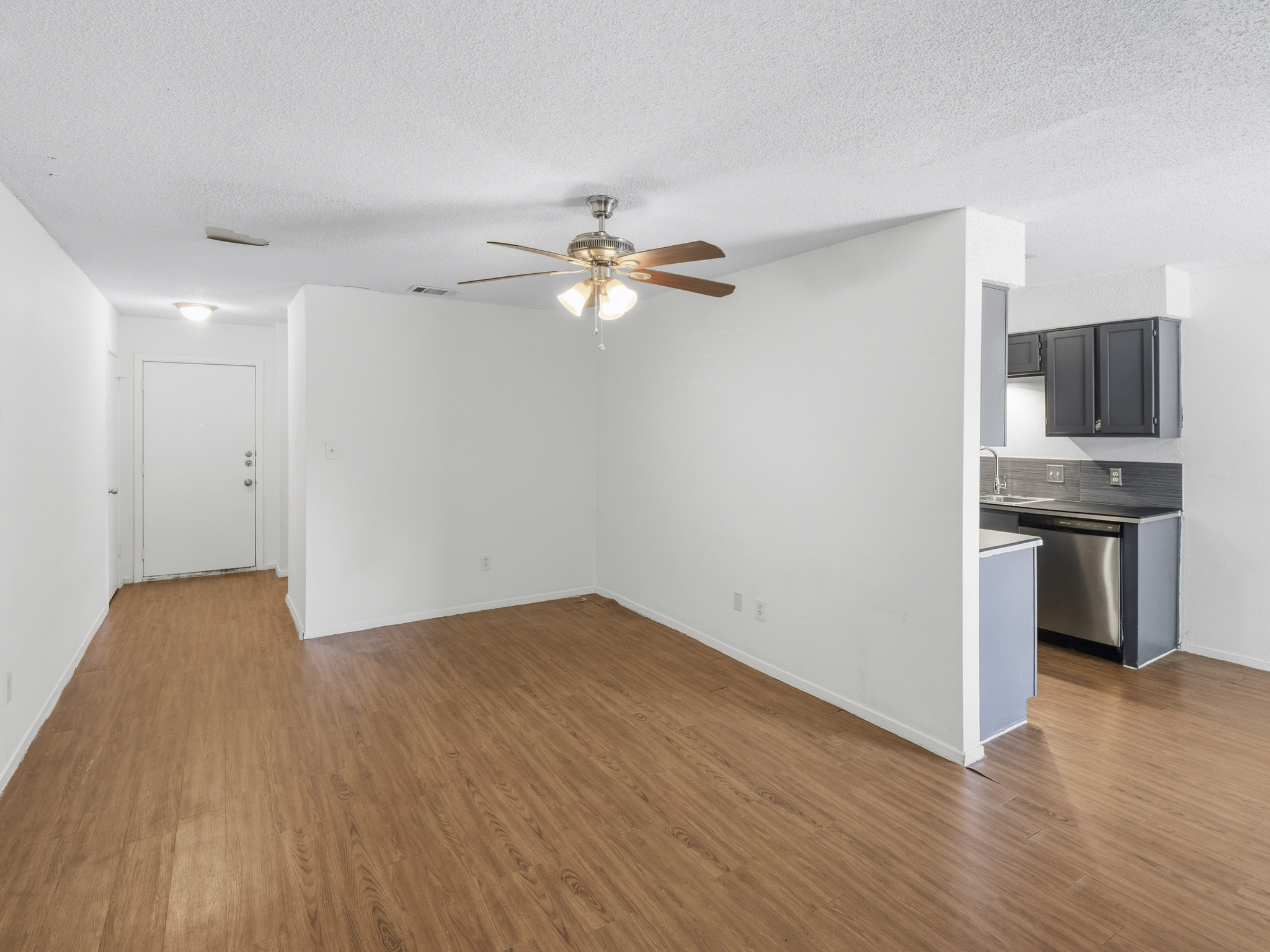 2401 Burleson Road Austin, TX 78741 - Photo 5 of 25 An inviting open-concept living space features warm wood-look flooring and a functional, modern kitchen.