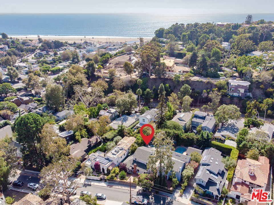 an aerial view of residential houses with outdoor space and trees