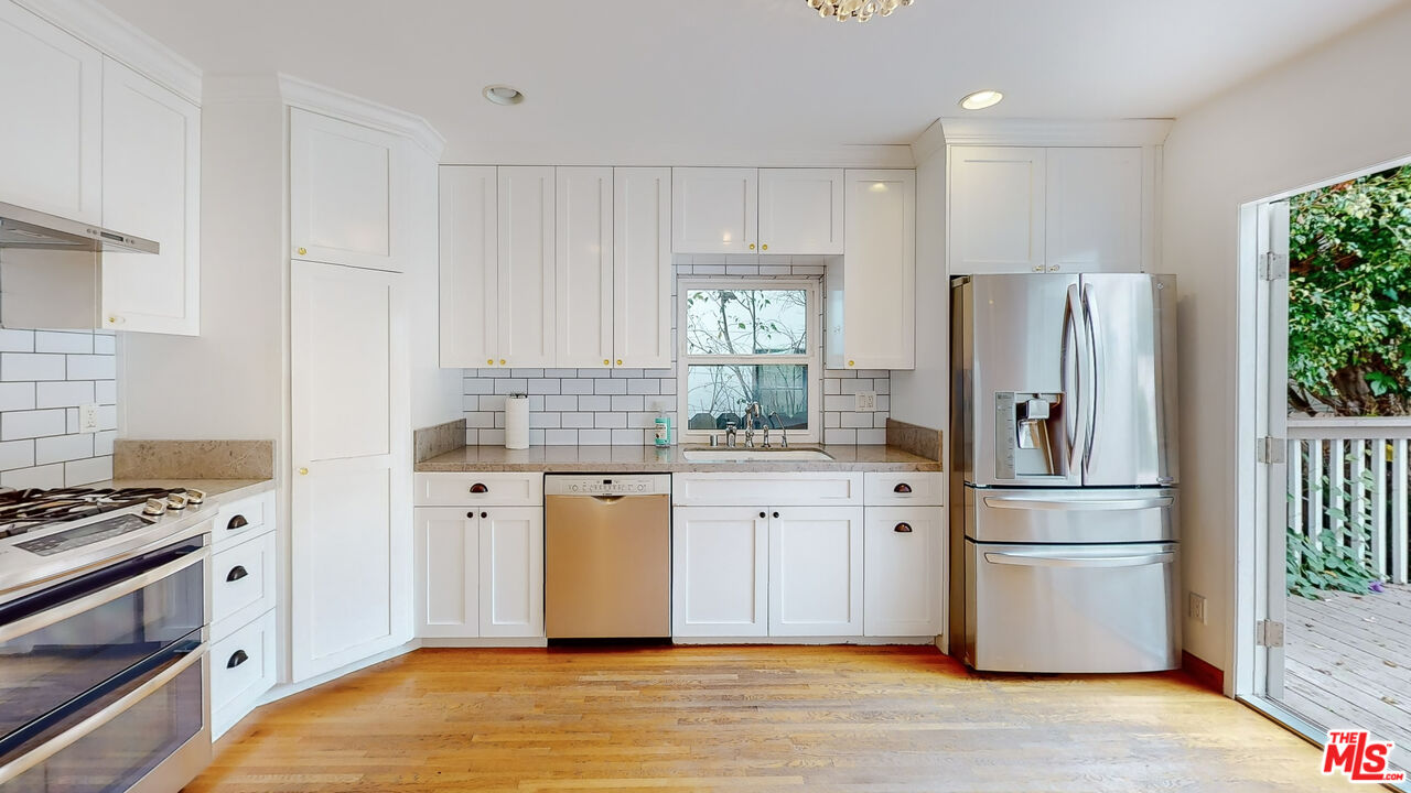 365 Sycamore Road Santa Monica, CA 90402 - Photo 12 of 42 a kitchen with granite countertop a refrigerator stove and wooden floor