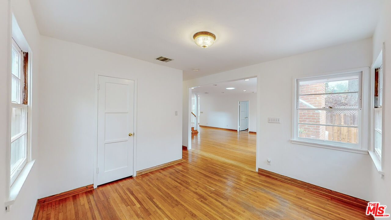 365 Sycamore Road Santa Monica, CA 90402 - Photo 9 of 42 an empty room with wooden floor and windows