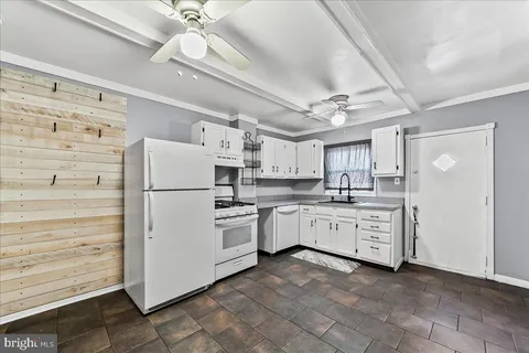 a kitchen with white cabinets and white appliances